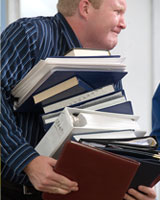 man with too much paperwork